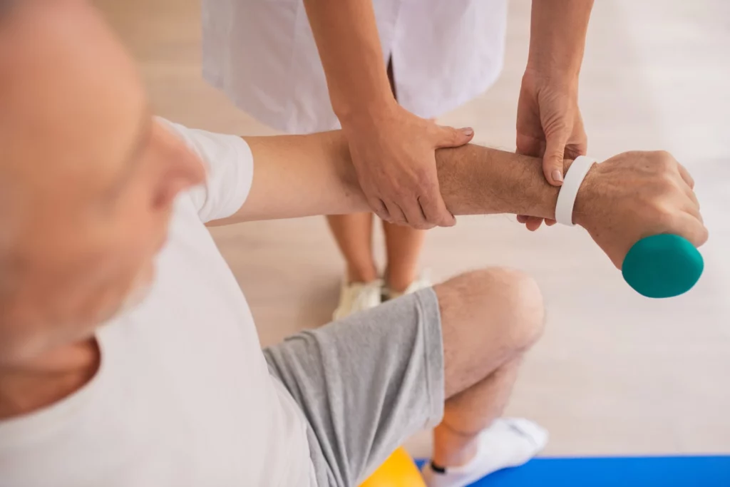 Mobile physiotherapist helping an elderly patient with post-surgery rehabilitation exercises during a home visit. South East Melbourne rehab.